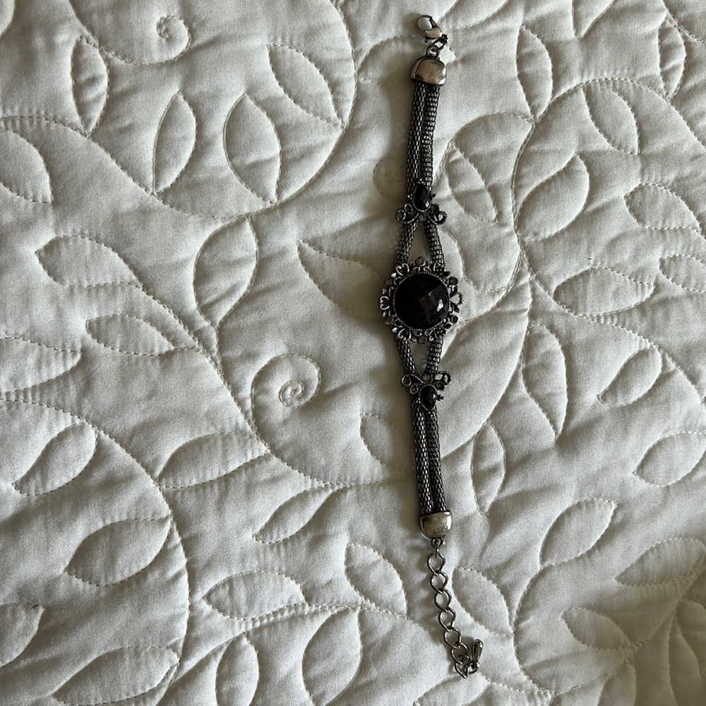 Silver bracelet; size adjustable.
